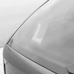 Blauw bordje met witte L voor lesvoertuigen